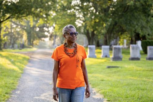 Musu Clemens walks through a cemetery.