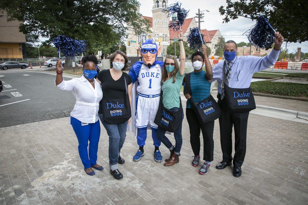 “Doing Good in the Neighborhood” champions drive up to get their swag and have their photo taken with the Duke Blue Devil mascot at the NC Mutual parking lot on Thursday morning September 30, 2021. (Ron Evans far Right.)