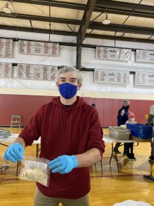 Student Brady Vaughan holds a bag of food he's packing