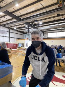 Chase Frutos smiles as he helps pack meals