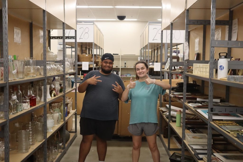 Two students posing in a storage room