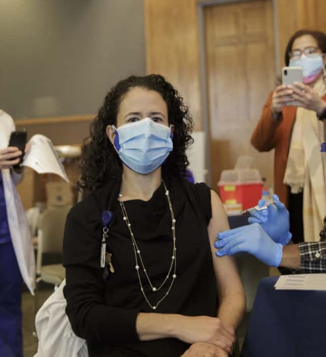 Latin-19 doctor in mask receiving a vaccination