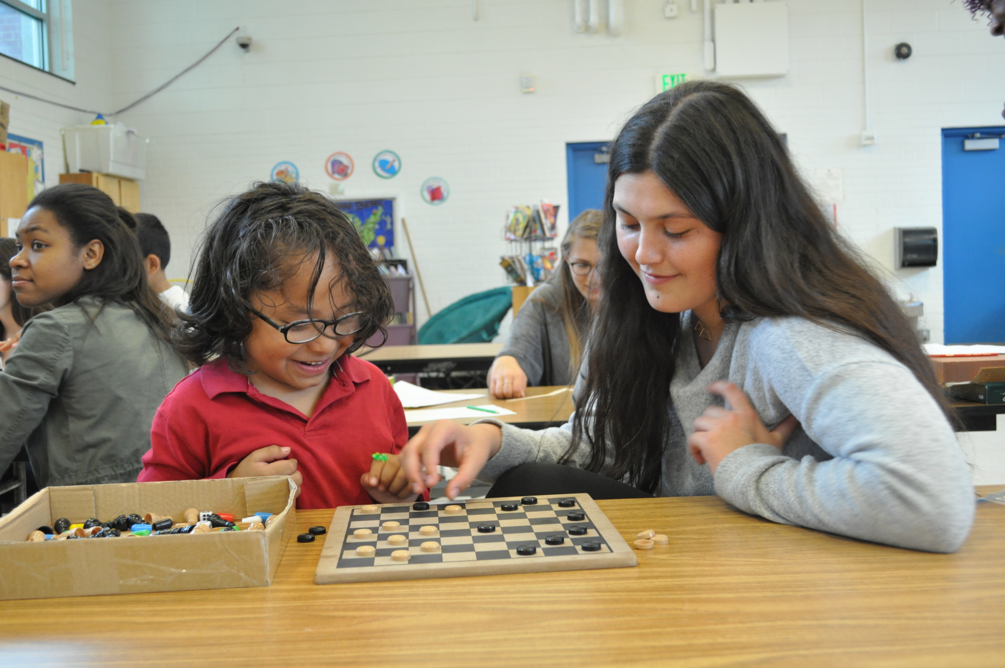 A Duke student tutoring a child while playing checkers