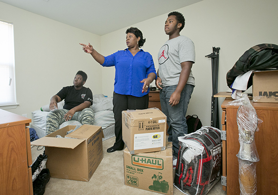 A family surrounded by boxes moves into their new home